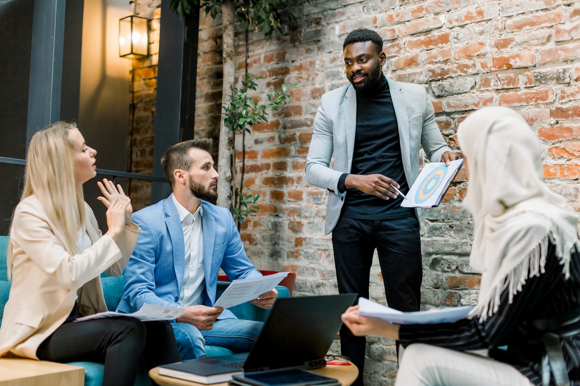 Handsome afro american businessman team leader, showing the paper sheet with marketing chart or